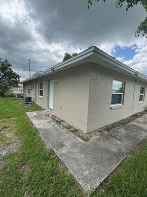 Fort Myers apartment for rent - A house with a grey roof and a white wall with a small window.