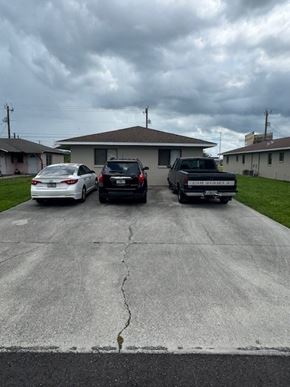Fort Myers apartment for rent - Three cars parked in a driveway in front of a house.