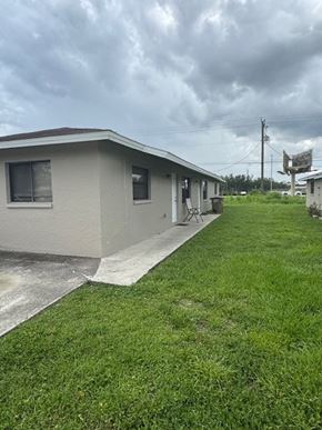 Fort Myers apartment for rent - A house with a grey roof and a green lawn.