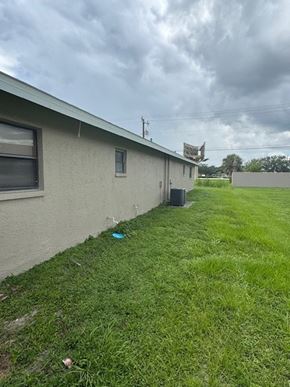 Fort Myers apartment for rent - A house with a green lawn and a blue object on the grass.