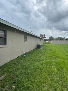 Fort Myers apartment for rent - A house with a green lawn and a blue frisbee on the ground.