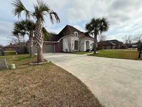 Lafayette house for rent - A house with a driveway and two palm trees in front.