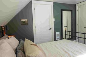 Scotsburn house for rent - A bedroom with a bed and a painting on the wall.