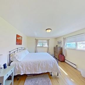 Englewood house for rent - A bedroom with a bed, nightstand, and window.