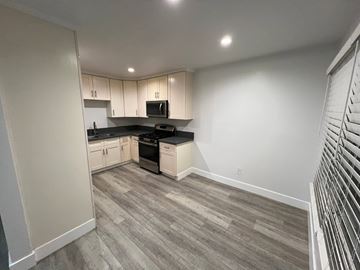 Gardena apartment for rent - A kitchen with a black countertop and white cabinets.