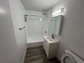 Gardena apartment for rent - A white bathroom with a toilet, sink, and shower.