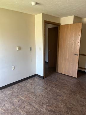 Delphos apartment for rent - A room with a tan wall and a brown door.