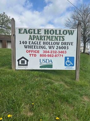 Wheeling apartment for rent - A sign for Eagle Hollow Apartments is displayed in a grassy area.