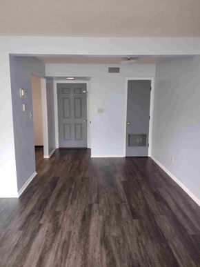 Byesville apartment for rent - A room with a dark wood floor and a grey door.