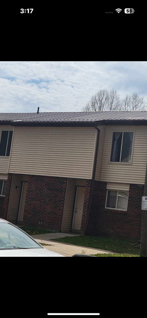 Logan apartment for rent - A building with a beige siding and a brown roof.