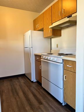 Malvern apartment for rent - A kitchen with a white refrigerator, white oven, and wooden cabinets.
