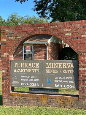 Minerva apartment for rent - A sign for Terrace Apartments and Minerva Senior Center is displayed on a brick wall.