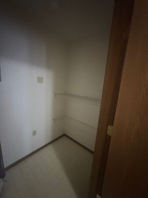 Minerva apartment for rent - A hallway with a white wall and a brown door.