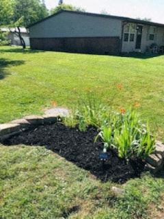 South Charleston apartment for rent - A flower bed in the middle of a grassy area.