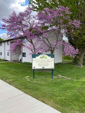 Bluffton apartment for rent - A sign for Bluffton Riverview Lodge stands in front of a building.