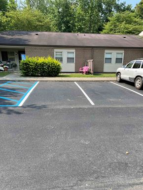 Morgantown apartment for rent - A parking lot with a white car and a blue painted area.