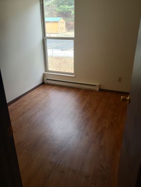 Summersville apartment for rent - A room with a window and a view of a parking lot and a building outside.