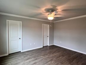 Gulfport house for rent - A room with a ceiling fan and two doors.