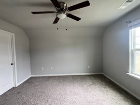 Gulfport house for rent - A room with a ceiling fan and carpeted floor.