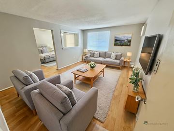 Denver apartment for rent - A living room with grey couches and a wooden coffee table.
