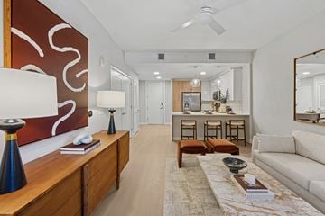 White Plains apartment for rent - A modern living room with a white couch, a wooden table, and a large painting on the wall.