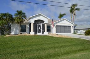Cape Coral house for rent - A white house with a black door and a flag on the front.