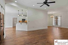 Hattiesburg house for rent - A spacious room with wooden floors and a ceiling fan.