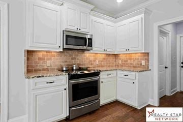 Hattiesburg house for rent - A kitchen with white cabinets and a brick backsplash.