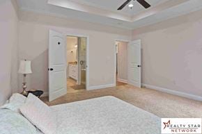 Hattiesburg house for rent - A bedroom with a bed, a lamp, and a ceiling fan.