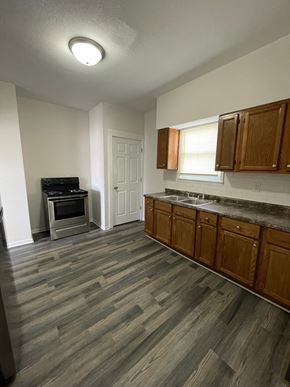 Lima house for rent - A kitchen with wooden cabinets and a grey floor.