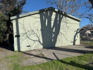 Corning house for rent - A green building with a tree shadow on it.