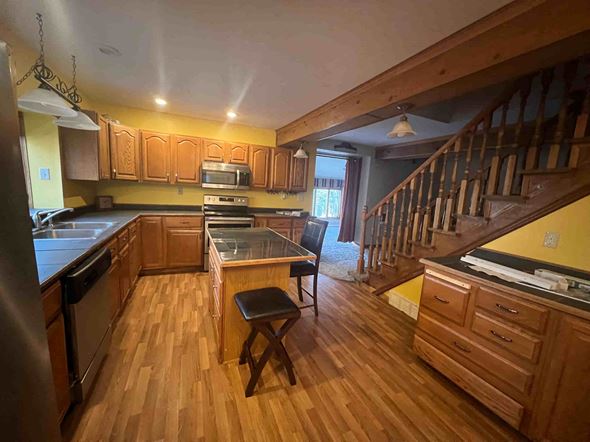 Bemidji house for rent - A kitchen with wooden floors and a staircase.