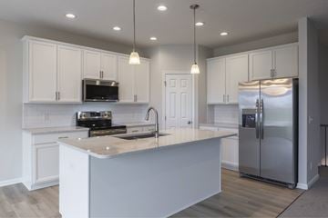 Gretna apartment for rent - A kitchen with white cabinets and a wooden island.
