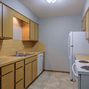 Omaha apartment for rent - A kitchen with wooden cabinets and a white refrigerator.