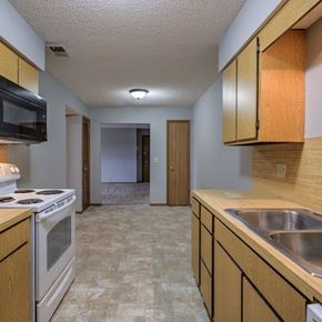 Omaha apartment for rent - A kitchen with a stove, microwave, and sink.