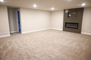Papillion apartment for rent - A spacious room with a carpeted floor and a fireplace.