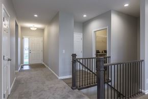Gretna apartment for rent - A hallway with a black railing and a white door.