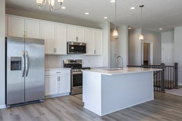 Gretna apartment for rent - A modern kitchen with a stainless steel refrigerator and white cabinets.