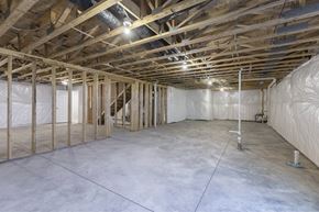 Gretna apartment for rent - A spacious unfinished room with wooden beams and insulation on the walls.