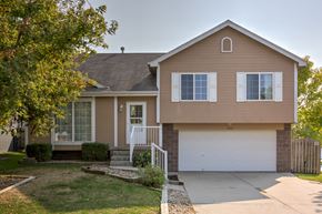 Omaha apartment for rent - A house with a brown exterior and a white garage door.