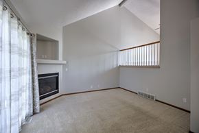Omaha apartment for rent - A living room with a fireplace and carpeted floor.