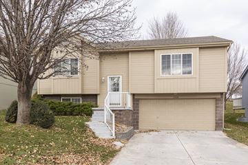 Omaha apartment for rent - A beige house with a white door and a small porch.