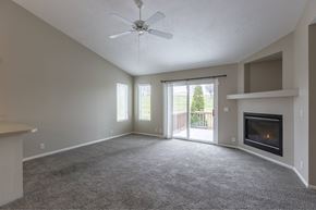 Omaha apartment for rent - A spacious living room with a fireplace and sliding glass doors.