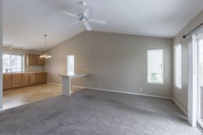 Omaha apartment for rent - A spacious room with a grey carpet and a ceiling fan.