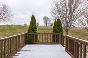 Omaha apartment for rent - A wooden deck with snow on it and evergreen trees in the background.