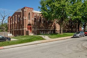 Council Bluffs apartment for rent - A red brick building with a green tree in front.