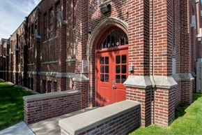 Council Bluffs apartment for rent - A red door is on the side of a brick building.