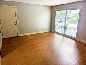 Omaha apartment for rent - A room with a wooden floor and a sliding glass door.