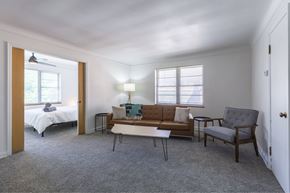 Omaha apartment for rent - A bedroom with a bed, couch, and chair.