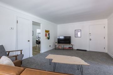 Omaha apartment for rent - A living room with a brown couch and a white table.